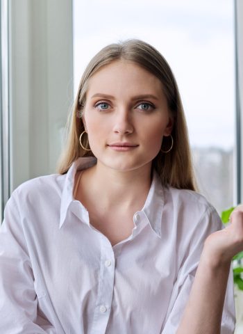 Head shot portrait of a young blonde woman looking at the camera